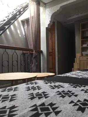 a bedroom with a black and white bed and tables at Riad Le Marrakech Berrima in Marrakech