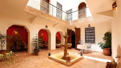 a living room with a fountain in the middle of it at Ryad Bianco in Marrakech
