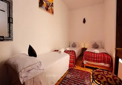 a room with two beds and a chair in it at Ryad Bianco in Marrakech