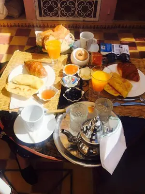 a breakfast table with breakfast foods and orange juice at Ryad Bianco in Marrakech
