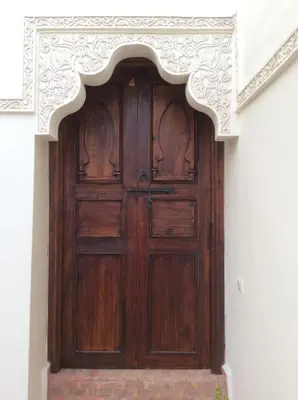 an ornate wooden door in a building at Ryad Bianco in Marrakech