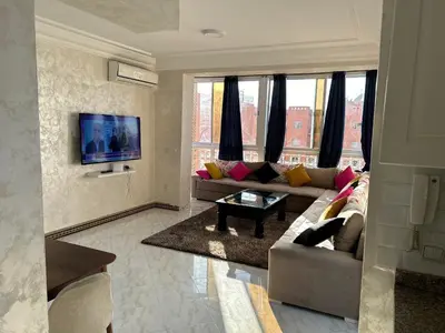 a living room with a couch and a tv at Susana home in Marrakech