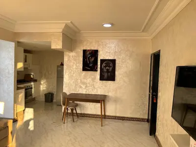 a living room with a table and a kitchen at Susana home in Marrakech
