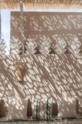 a shadow of a building on a wall with pillows at Riad M17 - Hammam & Spa in Marrakech