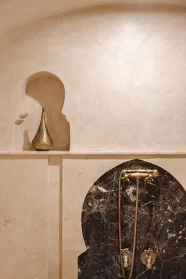 a bathroom with a shower with a bell on a shelf at Riad M17 - Hammam & Spa in Marrakech