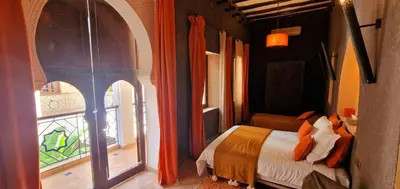 a bedroom with a bed with an arched window at Riad de Vincent in Marrakech