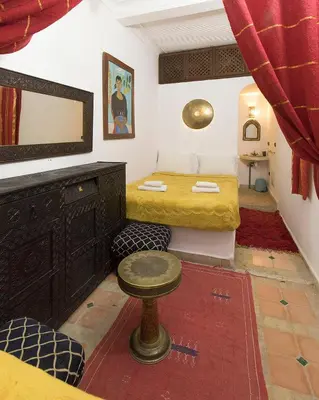 a bedroom with a bed and a table in a room at Riad Wardate Rita in Marrakech