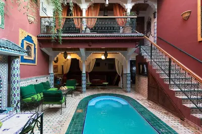 a house with a swimming pool next to a staircase at Riad Wardate Rita in Marrakech