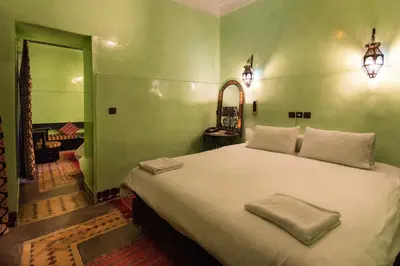 a bedroom with a large bed in a green room at Riad Omar in Marrakech