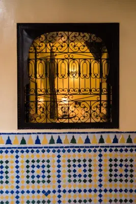 a window on a wall above a tiled counter at Riad Omar in Marrakech