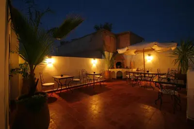 a patio with tables and chairs at night at Riad Morgane in Marrakech