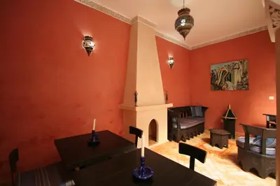 a living room with red walls and a fireplace at Riad Morgane in Marrakech