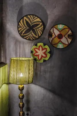 three plates hanging on a wall with a lamp at Dar Beija in Marrakech