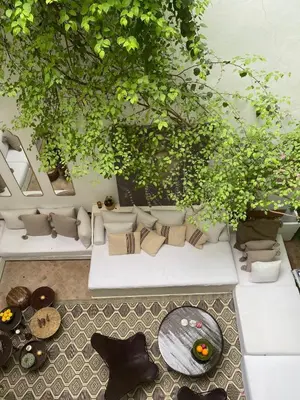 a living room with white couches and plants at Riad Wabisabi in Marrakech