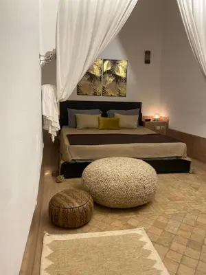 a bedroom with a bed and a large ottoman at Riad Wabisabi in Marrakech