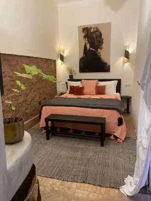 a bedroom with two beds and a potted plant at Riad Wabisabi in Marrakech