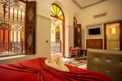 a bedroom with a red bed in a room at Riad Aymane in Marrakech