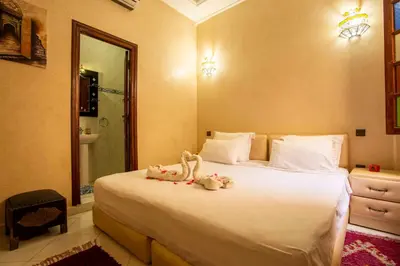 a bedroom with a bed with two stuffed animals on it at Riad Aymane in Marrakech