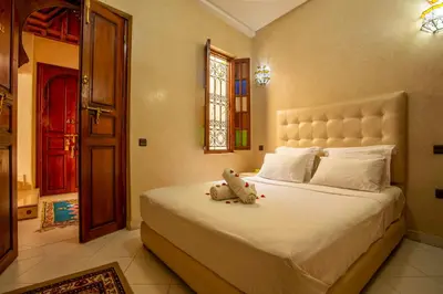 a teddy bear sitting on a bed in a bedroom at Riad Aymane in Marrakech