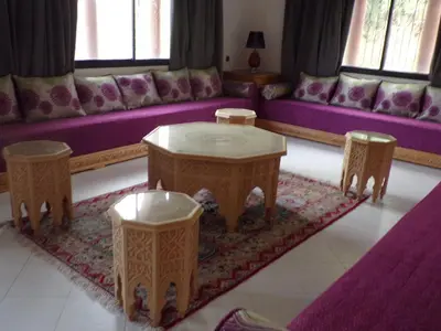 a living room with a couch and a table and two stools at Villa clos Odette in Marrakech
