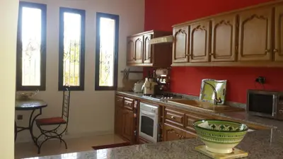 a kitchen with wooden cabinets and a counter top at Villa clos Odette in Marrakech