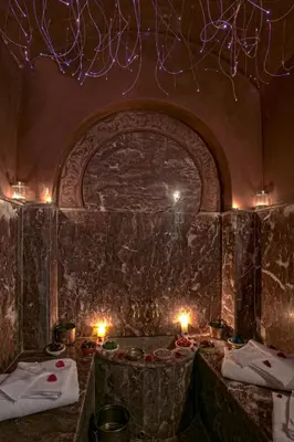a room with a stone wall with lights and candles at RIAD DREAMS in Marrakech