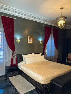a bedroom with a large bed with red curtains at RIAD DREAMS in Marrakech