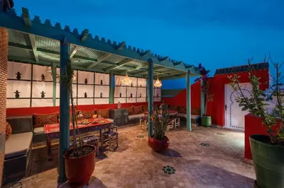 a patio with a table and potted plants at Emma's Riad in Marrakech