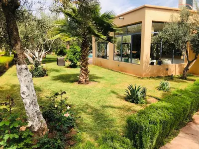 a house with a palm tree in a yard at Boutique Hotel Katia in El Harkat