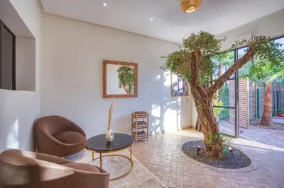 a living room with a tree and a chair and a table at Boutique Hotel Katia in El Harkat