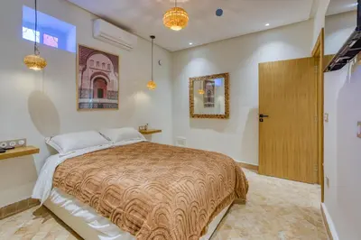 a bedroom with a bed and a wooden door at Boutique Hotel Katia in El Harkat