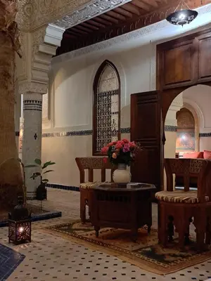 a lobby with a vase of flowers on a table at Dar Al Kounouz in Marrakech