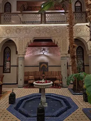 a large room with a fountain in the middle of a building at Dar Al Kounouz in Marrakech
