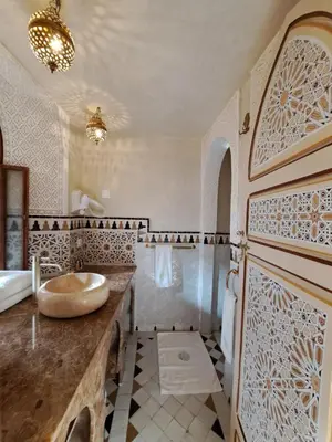 a bathroom with a sink and a counter with a tub at Dar Al Kounouz in Marrakech