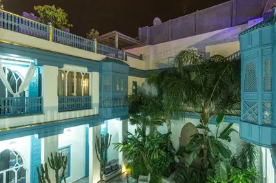 a view of the pool of a hotel at night at Riad Le Perroquet Bleu Suites & Spa in Marrakech