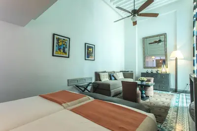 a bedroom with a bed and a living room at Riad Le Perroquet Bleu Suites & Spa in Marrakech