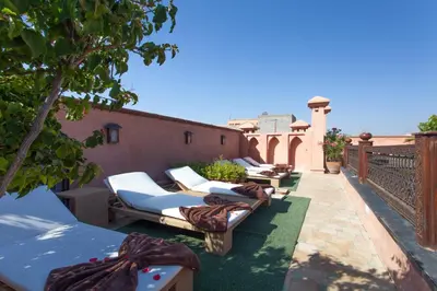 a row of chaise lounges on a patio at Riad Le Perroquet Bleu Suites & Spa in Marrakech