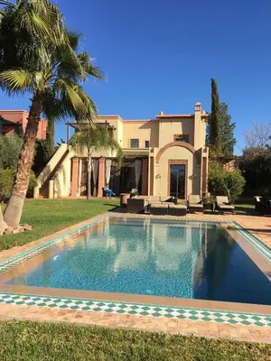 a swimming pool in front of a house at Villa entière GOLF MARRAKECH in Marrakech