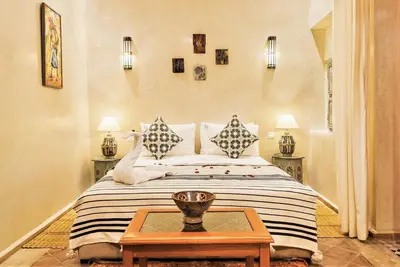 a bedroom with a bed with two pillows and a table at Riad Tahyra in Marrakech