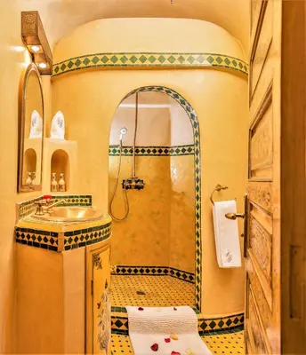 a bathroom with a shower with a sink and a mirror at Riad Tahyra in Marrakech