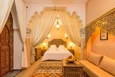 a bedroom with a bed and a table with a bowl of fruit at Riad Tahyra in Marrakech