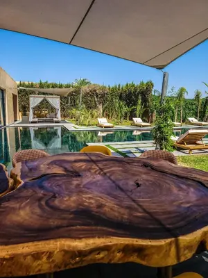 a bedroom with a table and a swimming pool at Villa Oxygène Marrakech in Marrakech