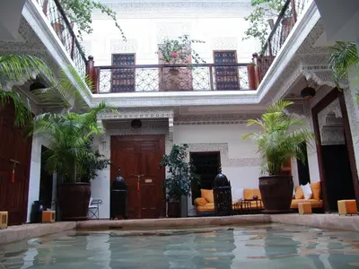 an indoor swimming pool in a building with plants at Riad Les Nuits de Marrakech in Marrakech