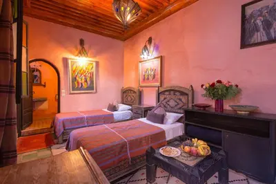 a hotel room with two beds and a piano at Riad Lalla Khiti in Marrakech