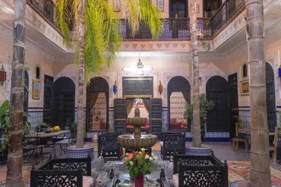 a lobby with a fountain and tables and chairs at Riad Lalla Khiti in Marrakech