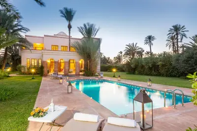 a swimming pool in front of a house at Domaine Rosaroum in Marrakech