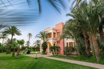 a house with palm trees in front of it at Domaine Rosaroum in Marrakech