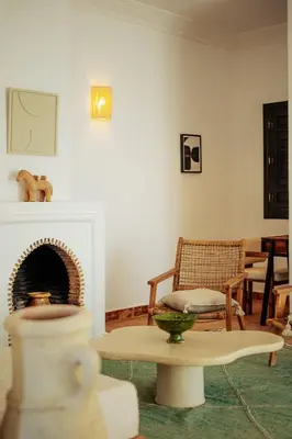 a living room with a fireplace and a table and a chair at Residence Dar Lamia Marrakech in Dar Caïd Layadi
