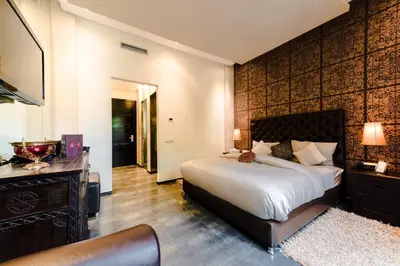a bedroom with a large bed and a television at Residence Dar Lamia Marrakech in Dar Caïd Layadi