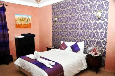 a bedroom with a bed with white towels on it at Riad Mhidou in Marrakech